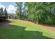 A large, grassy backyard featuring mature trees and natural surroundings, perfect for outdoor activities and relaxation at 2968 Ovalene Sw Ct, Marietta, GA 30064