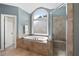 Bathroom featuring a large soaking tub, glass-enclosed shower, and tiled surround at 2968 Ovalene Sw Ct, Marietta, GA 30064