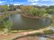 Picturesque aerial view of a tranquil pond surrounded by lush trees, offering a serene and natural setting at 1882 Copelyn Reese Court (Lot 167), Lawrenceville, GA 30043