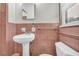 Neat bathroom featuring pink tiling around the sink, toilet, and walls at 2320 Tilson Cir, Decatur, GA 30032