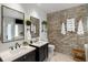 Bright modern bathroom with double sinks, exposed brick accent wall, and modern fixtures at 1354 Fernwood Ne Cir, Brookhaven, GA 30319