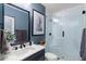 Modern bathroom featuring a glass shower, a blue accent wall, and a marble countertop vanity at 1354 Fernwood Ne Cir, Brookhaven, GA 30319