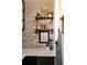 Decorated hall with a white quartz countertop, dark cabinets, shelves, exposed brick wall, and dark framed art at 1354 Fernwood Ne Cir, Brookhaven, GA 30319