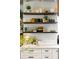 Charming kitchen features open shelving with dishware and decor, complemented by white cabinets and marble countertops at 1354 Fernwood Ne Cir, Brookhaven, GA 30319