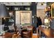 Stylish living room featuring leather armchairs, a bar area, brick walls, and exposed ceiling beams at 1354 Fernwood Ne Cir, Brookhaven, GA 30319