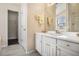 Well-lit bathroom featuring white cabinets, a large mirror, and a combination shower and tub at 257 Se Ashland Park Se Ct, Lawrenceville, GA 30045