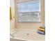 Close up of bathtub in bathroom featuring window with blinds and towels at 257 Se Ashland Park Se Ct, Lawrenceville, GA 30045