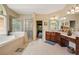 Bright bathroom featuring a walk-in shower and separate soaking tub with arched window at 3227 Collier Gate Se Ct, Smyrna, GA 30080