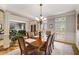 Bright dining room with wood floors, a classic chandelier, and views of the living room at 3227 Collier Gate Se Ct, Smyrna, GA 30080