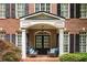 Close-up of a brick home's entry, showcasing a covered porch with chairs at 3227 Collier Gate Se Ct, Smyrna, GA 30080