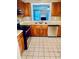 Bright kitchen with wood cabinets, stainless steel appliances, and view into living area at 401 Autumn Leaf Way, Norcross, GA 30093