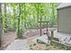 Picturesque backyard featuring a stone patio, fire pit, and wooded surroundings at 4246 Loch Highland Ne Pkwy, Roswell, GA 30075