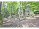 Backyard with a fire pit, wooded area, and staircase leading up to the home at 4246 Loch Highland Ne Pkwy, Roswell, GA 30075