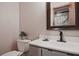Cozy bathroom features single sink vanity, neutral paint and rustic barn door in the mirror at 4246 Loch Highland Ne Pkwy, Roswell, GA 30075