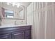 Bathroom features a dark wood vanity with marble countertop and framed mirror at 4246 Loch Highland Ne Pkwy, Roswell, GA 30075