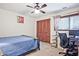 Cozy bedroom features a ceiling fan, closet with louvered doors, and a sunny window at 4246 Loch Highland Ne Pkwy, Roswell, GA 30075
