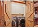 Laundry room with modern washer and dryer, hidden behind rustic barn doors for a farmhouse feel at 4246 Loch Highland Ne Pkwy, Roswell, GA 30075