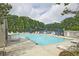 Beautiful swimming pool with lounge chairs and umbrellas, overlooking a tranquil lake at 4246 Loch Highland Ne Pkwy, Roswell, GA 30075