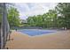 Outdoor tennis courts with players visible in the distance, surrounded by lush green trees at 4246 Loch Highland Ne Pkwy, Roswell, GA 30075
