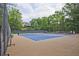 Well-maintained tennis courts with players and a view of a large house in a community setting at 4246 Loch Highland Ne Pkwy, Roswell, GA 30075