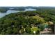 Expansive aerial view showcases a lakefront property with lush greenery and mature trees surrounding the home at 5340 Young Deer Dr, Cumming, GA 30041