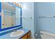 Clean and simple bathroom with blue walls, vanity, toilet, and tiled shower area at 5340 Young Deer Dr, Cumming, GA 30041