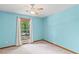 This bedroom has a ceiling fan and features light blue walls and a large window that lets in light at 5340 Young Deer Dr, Cumming, GA 30041