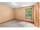 A simple bedroom featuring a window overlooking greenery and neutral-colored walls at 5340 Young Deer Dr, Cumming, GA 30041