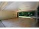Spacious carport area featuring concrete flooring, exposed beams, and a side door entrance at 5340 Young Deer Dr, Cumming, GA 30041