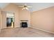 Cozy living room with fireplace, neutral carpeting, ceiling fan, and light-filled view to the doorway at 5340 Young Deer Dr, Cumming, GA 30041
