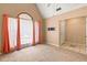 Light-filled living room features large window with curtains, neutral carpeting, and view to a doorway at 5340 Young Deer Dr, Cumming, GA 30041