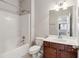 Bathroom features a shower-tub combo, a single sink vanity, and a mirror at 5655 Stevehaven Ln, Cumming, GA 30028