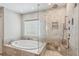 Bathroom featuring soaking tub and glass enclosed shower, all surrounded by beautiful tile at 5655 Stevehaven Ln, Cumming, GA 30028