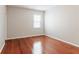 A simple bedroom with hardwood floors and a window offering natural light at 5655 Stevehaven Ln, Cumming, GA 30028