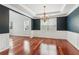 Dining room with a modern chandelier, hardwood floors, and white wainscoting at 5655 Stevehaven Ln, Cumming, GA 30028