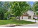 Beautiful home with a manicured lawn, mature trees, and a two-car garage at 5655 Stevehaven Ln, Cumming, GA 30028