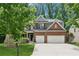 Charming brick two-story home featuring a two-car garage and a beautifully landscaped front yard at 5655 Stevehaven Ln, Cumming, GA 30028