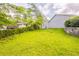 Backyard featuring lush green grass, some shade trees, and a stone garden bed at 225 Fireside Way, Fairburn, GA 30213