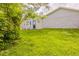 Spacious backyard with lush green grass, home exterior with rock details and private back entry at 225 Fireside Way, Fairburn, GA 30213