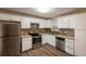 Updated kitchen featuring white cabinets, stainless steel appliances, and modern tile backsplash at 225 Fireside Way, Fairburn, GA 30213