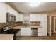 Updated kitchen featuring white cabinets, stainless steel appliances, and modern tile backsplash at 225 Fireside Way, Fairburn, GA 30213