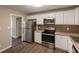 Updated kitchen featuring white cabinets, stainless steel appliances, and modern tile backsplash at 225 Fireside Way, Fairburn, GA 30213