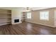 Inviting living room featuring a stone fireplace, built-in shelves, and hardwood floors at 225 Fireside Way, Fairburn, GA 30213