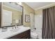 Bathroom features a white vanity with storage and a shower-tub combo at 255 Broken Lance Pl, Johns Creek, GA 30022