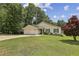 Attractive single-story home with a two-car garage, lush green lawn, and mature trees at 255 Broken Lance Pl, Johns Creek, GA 30022