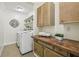 Well-maintained laundry room with tile floors, storage cabinetry and counter space at 255 Broken Lance Pl, Johns Creek, GA 30022