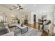 Cozy living room open to dining, featuring hardwood floors, stylish furniture and a ceiling fan at 255 Broken Lance Pl, Johns Creek, GA 30022