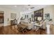 Inviting living room featuring hardwood floors, a stone fireplace, and an open layout to the dining area at 255 Broken Lance Pl, Johns Creek, GA 30022