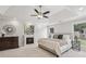 Calm, bright primary bedroom suite with a tray ceiling, ceiling fan, and a cozy fireplace at 255 Broken Lance Pl, Johns Creek, GA 30022