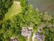 Stunning aerial view of a luxury home with a pool and lush landscaping near the water at 8470 Lazy Oaks Ct, Atlanta, GA 30350